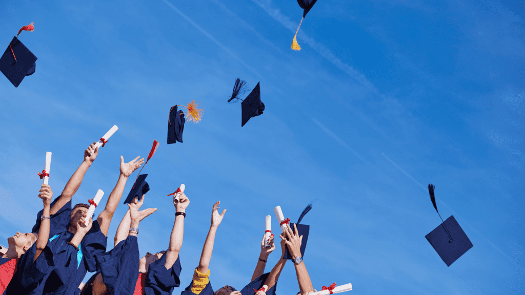 Students toss graduation caps.