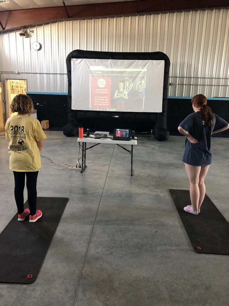 Two students follow along to a dance fitness workout.