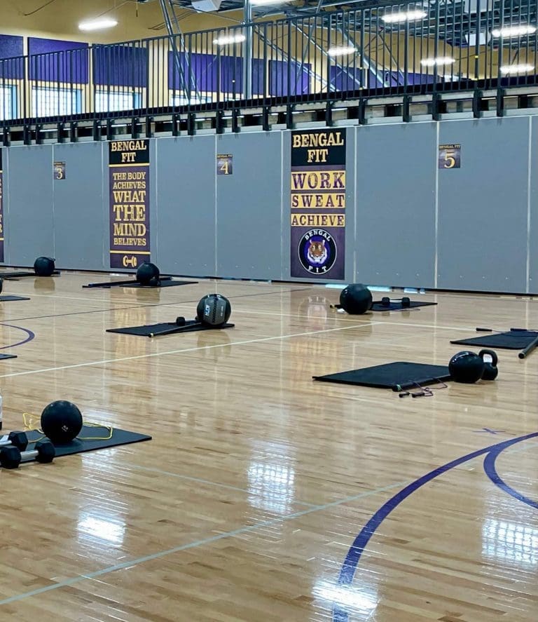 Medballls and kettlebells on the floor of Lewiston High School gym.