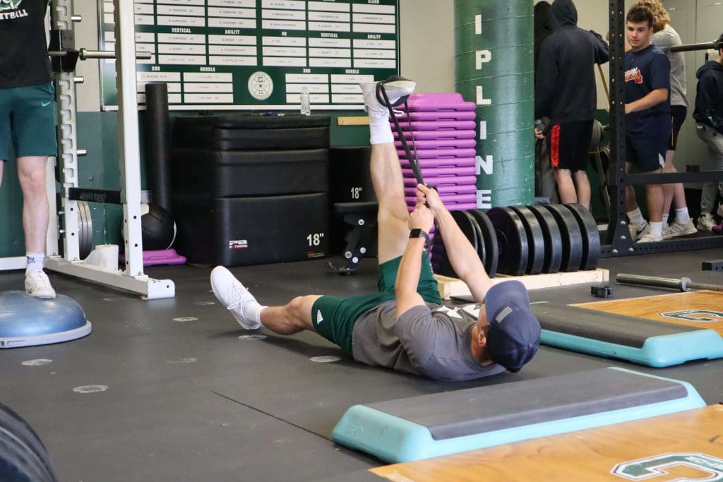A student stretches in the weight room.