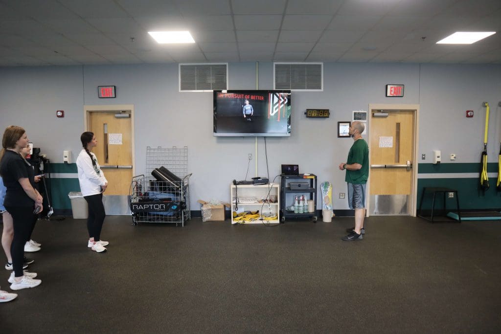 Students watch a PLT4M instructional video in PE class.