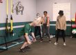 A teacher explains the points of performance of an air squat during physical education class.