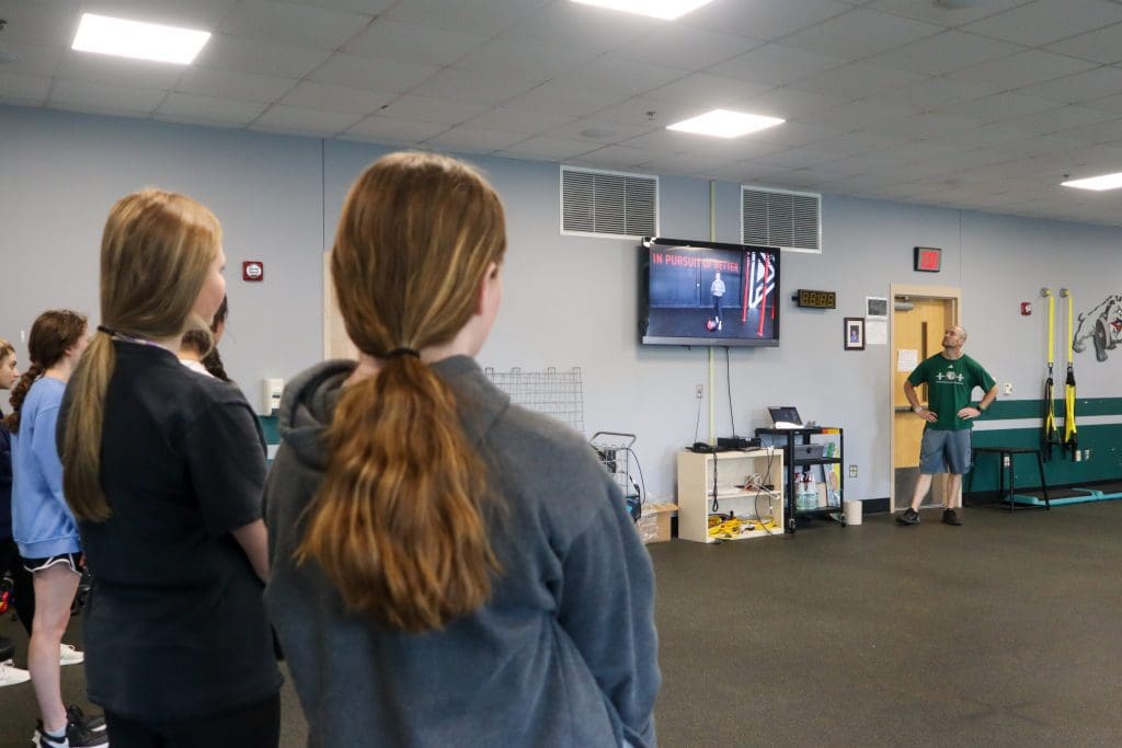 Students watch a PLT4M instructional video during PE class.