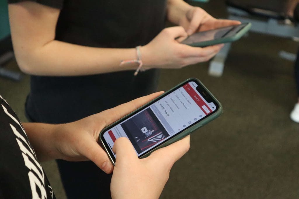 Students use the PLT4M app during a fitness lesson in PE class.