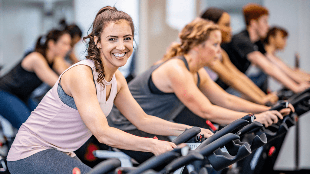 A person smiles while taking a spin class.