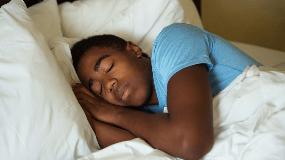 Teenager sleeping in bed.