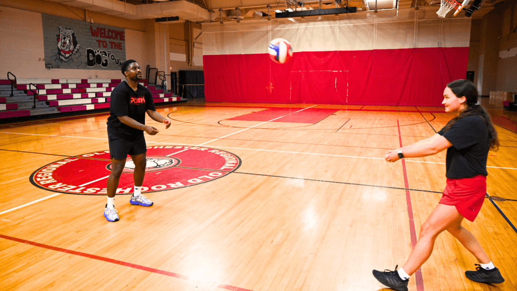 Player tossing the ball to partner for them to practice bump in volleyball.